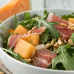 Salade-de-roquette-melon-jambon-cru-pignons.webp